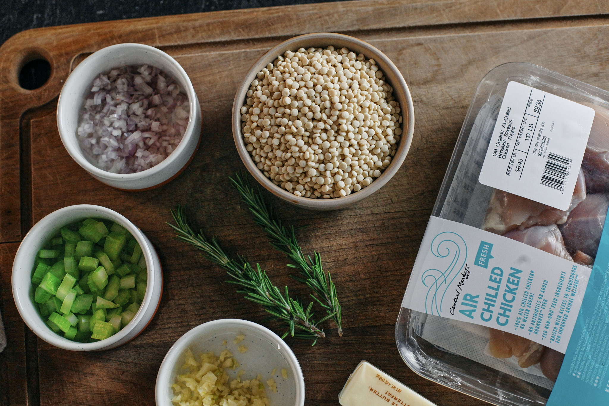 prep for the caramelized lemon chicken soup: shallots, celery, garlic, rosemary, butter, pearl couscous and chicken thighs.