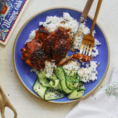 sticky sesame dijon chicken over rice with a cucumber salad