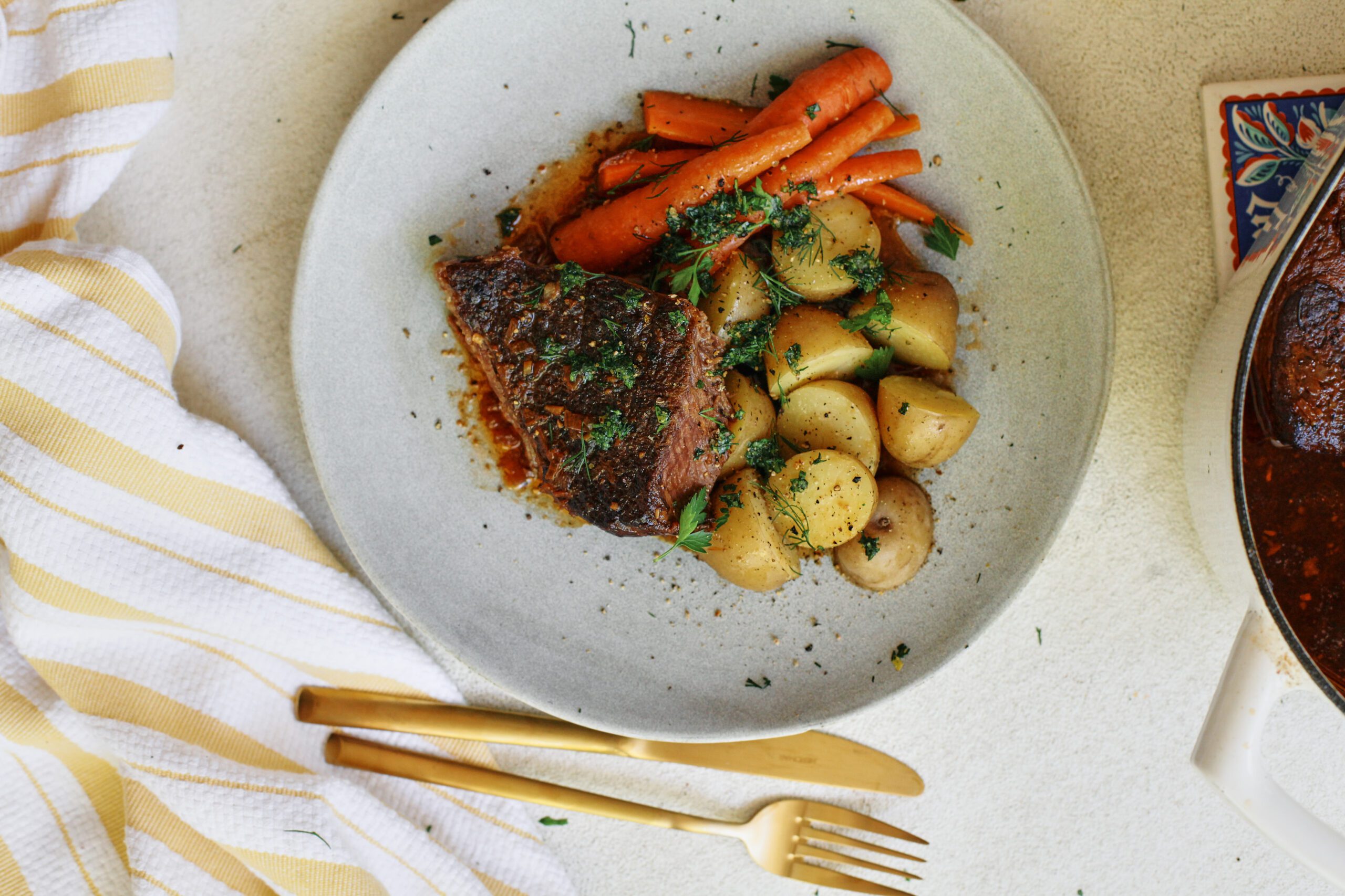 ale braised pot roast plated with baby potatoes and carrots