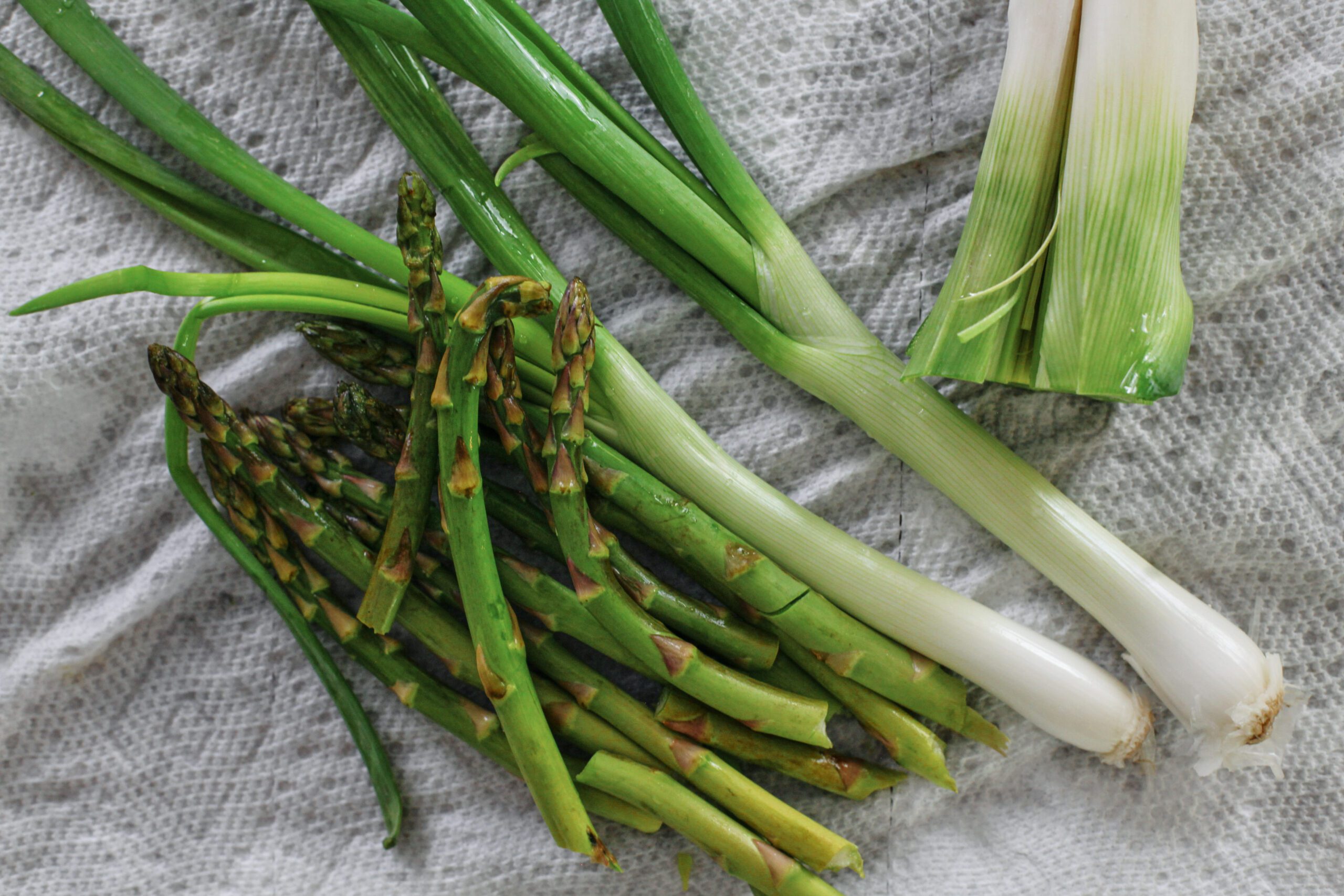washed veggies for the recipe (asparagus, green onion, leek)