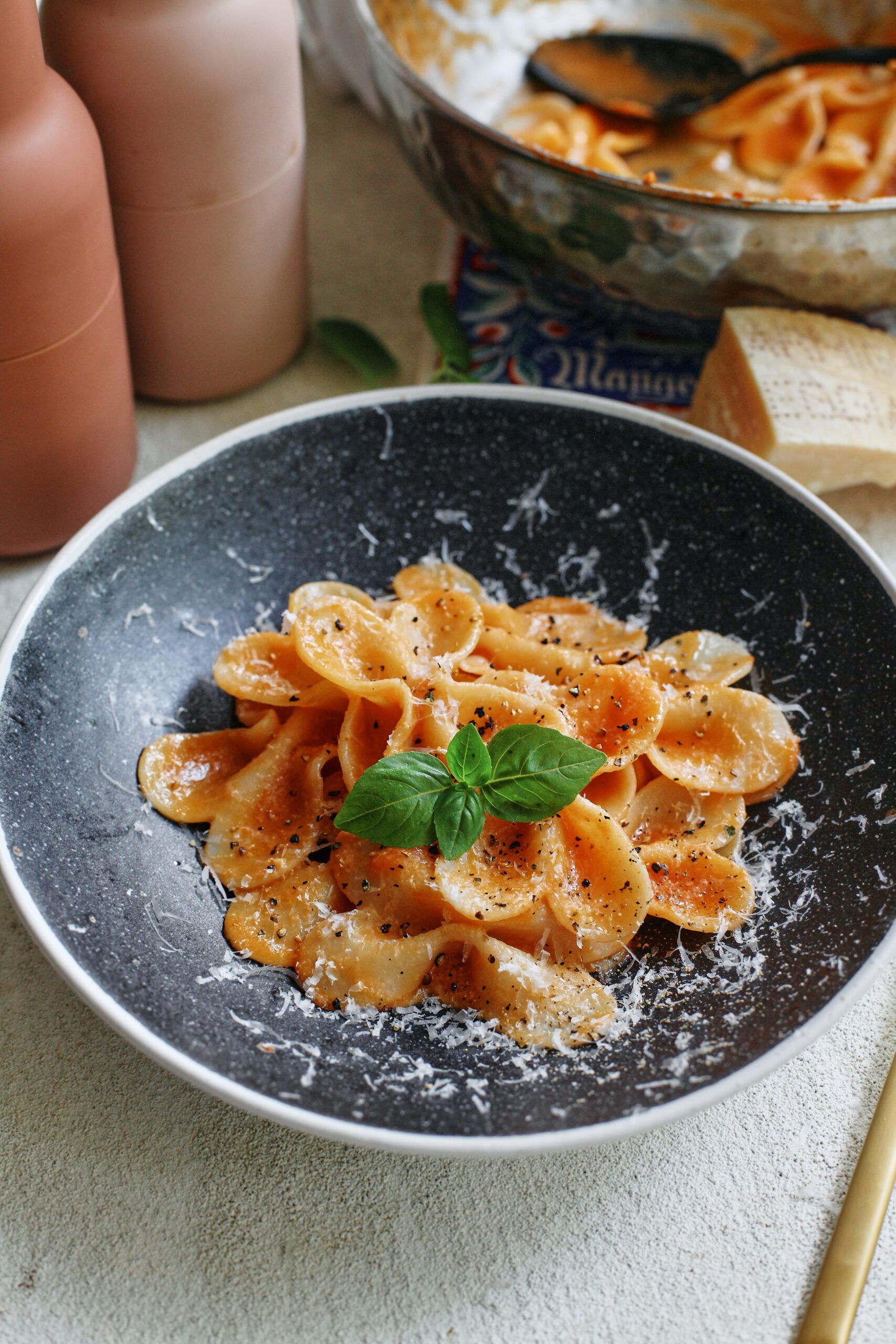 single serve tomato pasta garnished with parmesan and basil