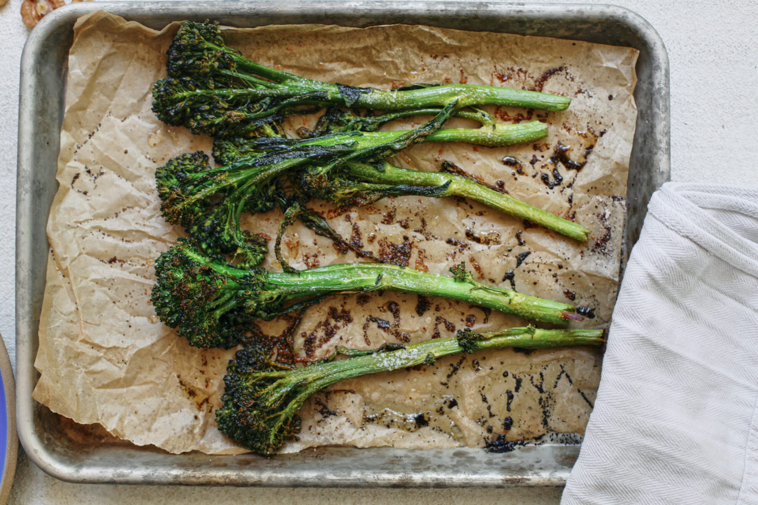 roasted broccolini on parchment paper on a sheet pan