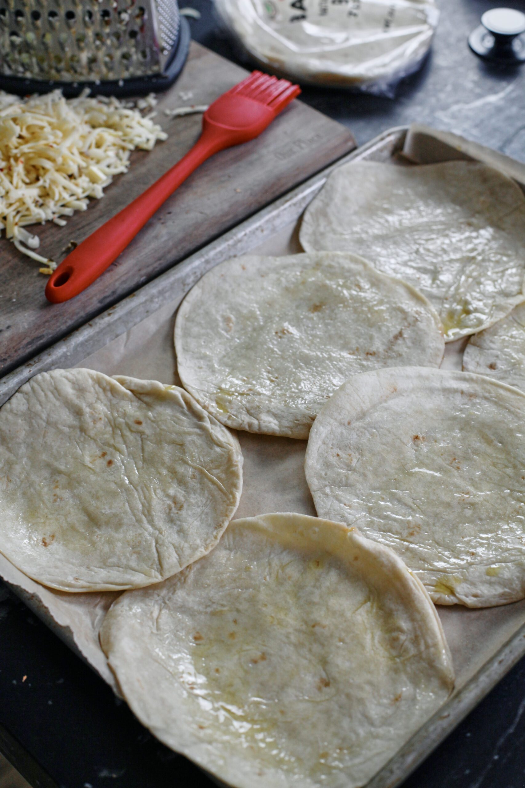 tortillas on a sheet pan brushed with olive oil
