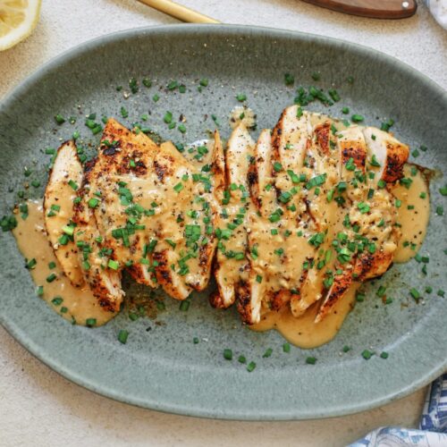 sliced chicken breast with the garlic shallot cream sauce poured on top finished with chives