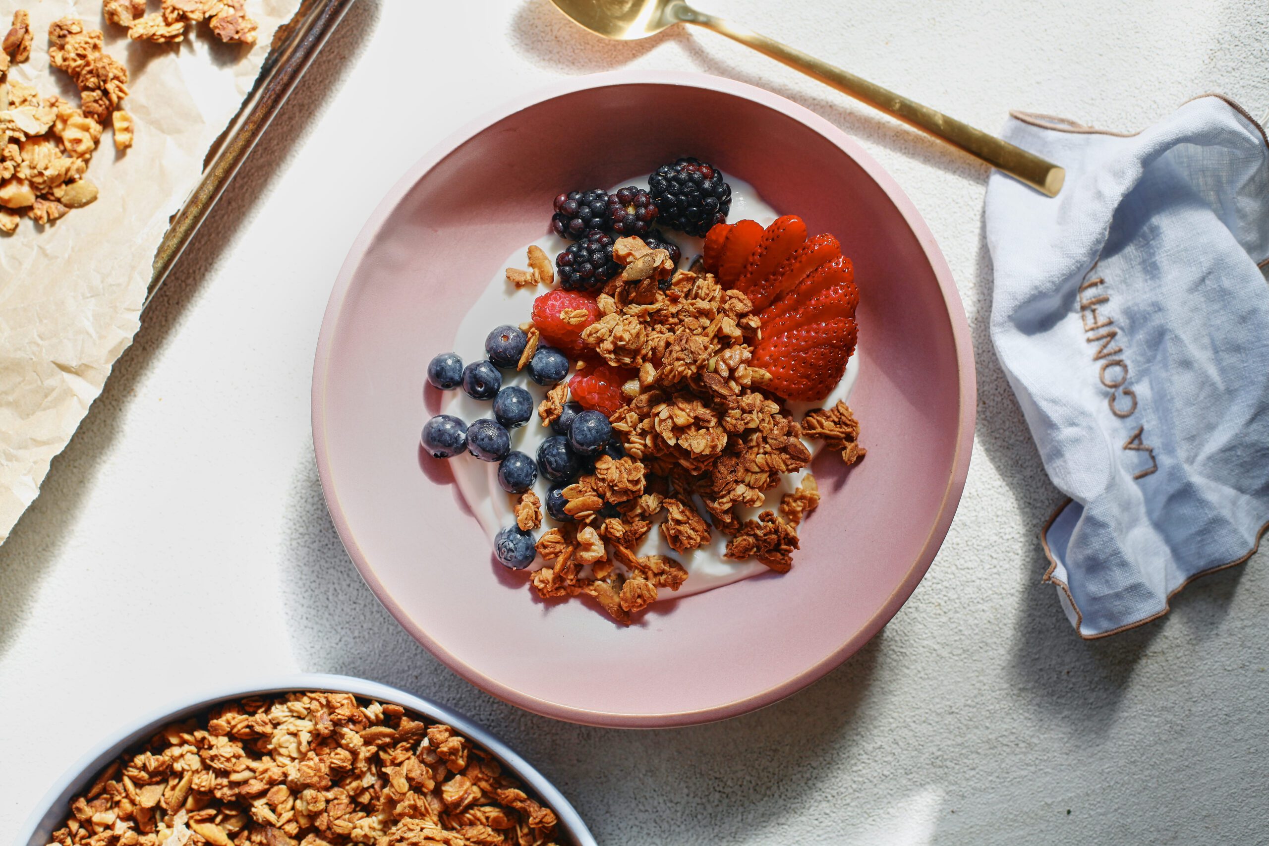 sourdough discard granola in a bowl over yogurt and berries