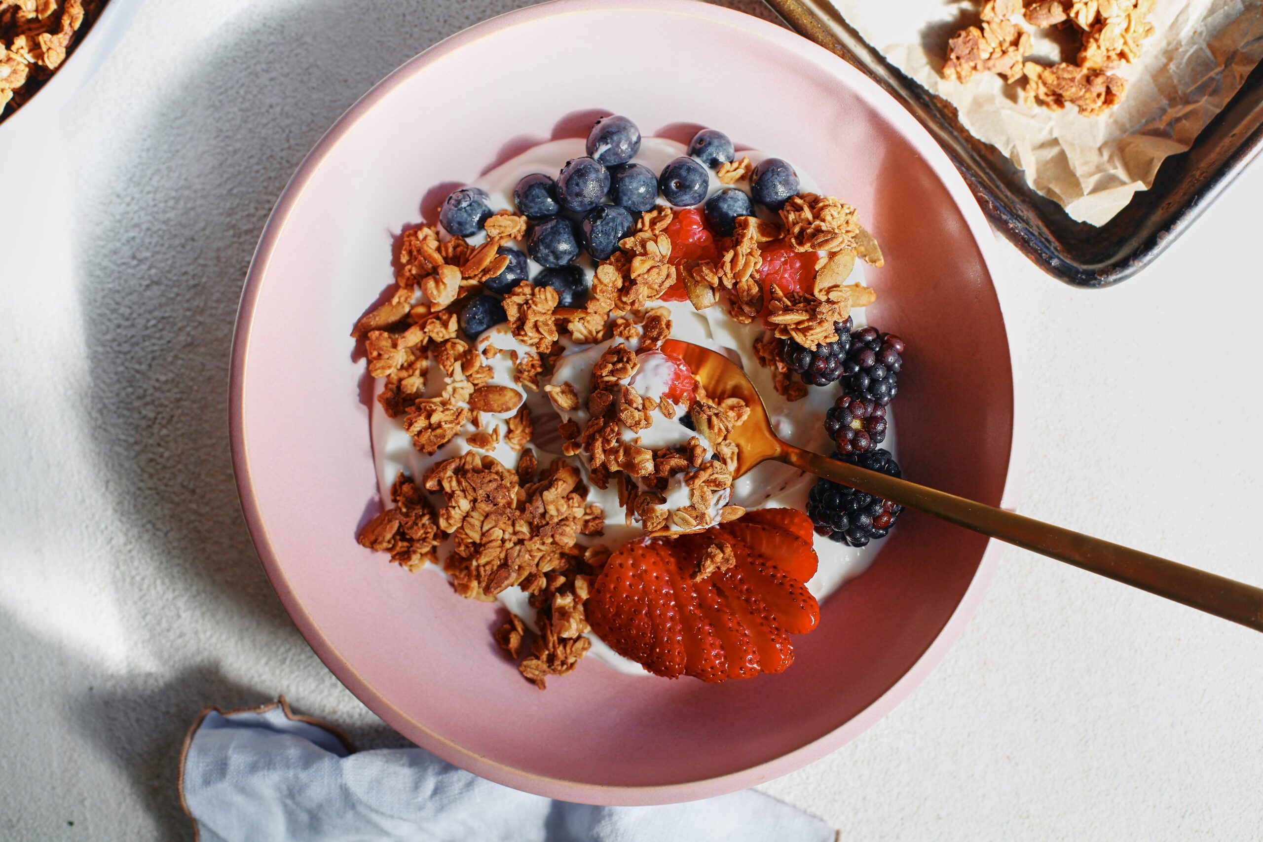 sourdough discard granola in a bowl over yogurt and berries