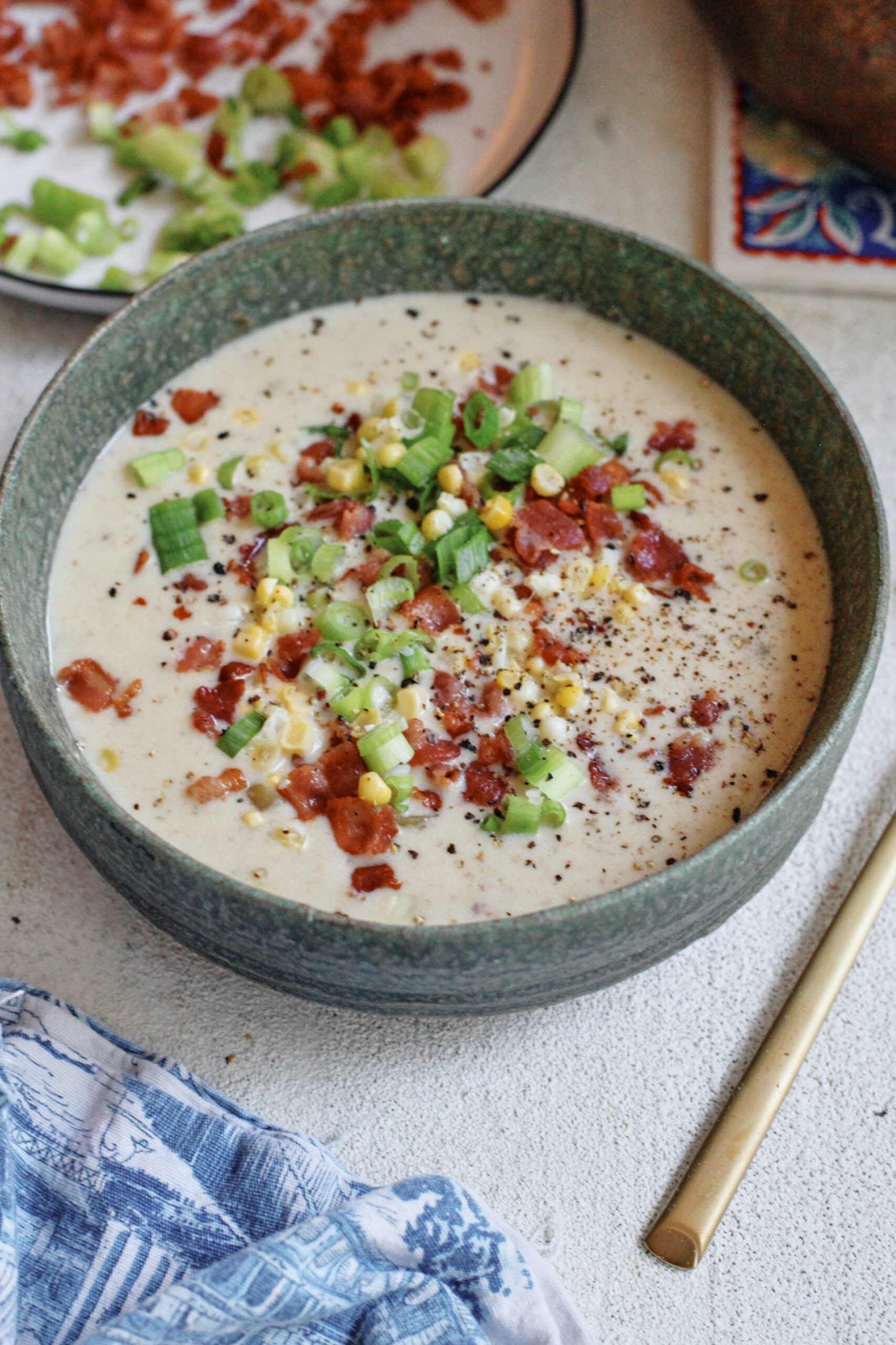 creamy corn chowder topped with green onions, bacon, and black pepper
