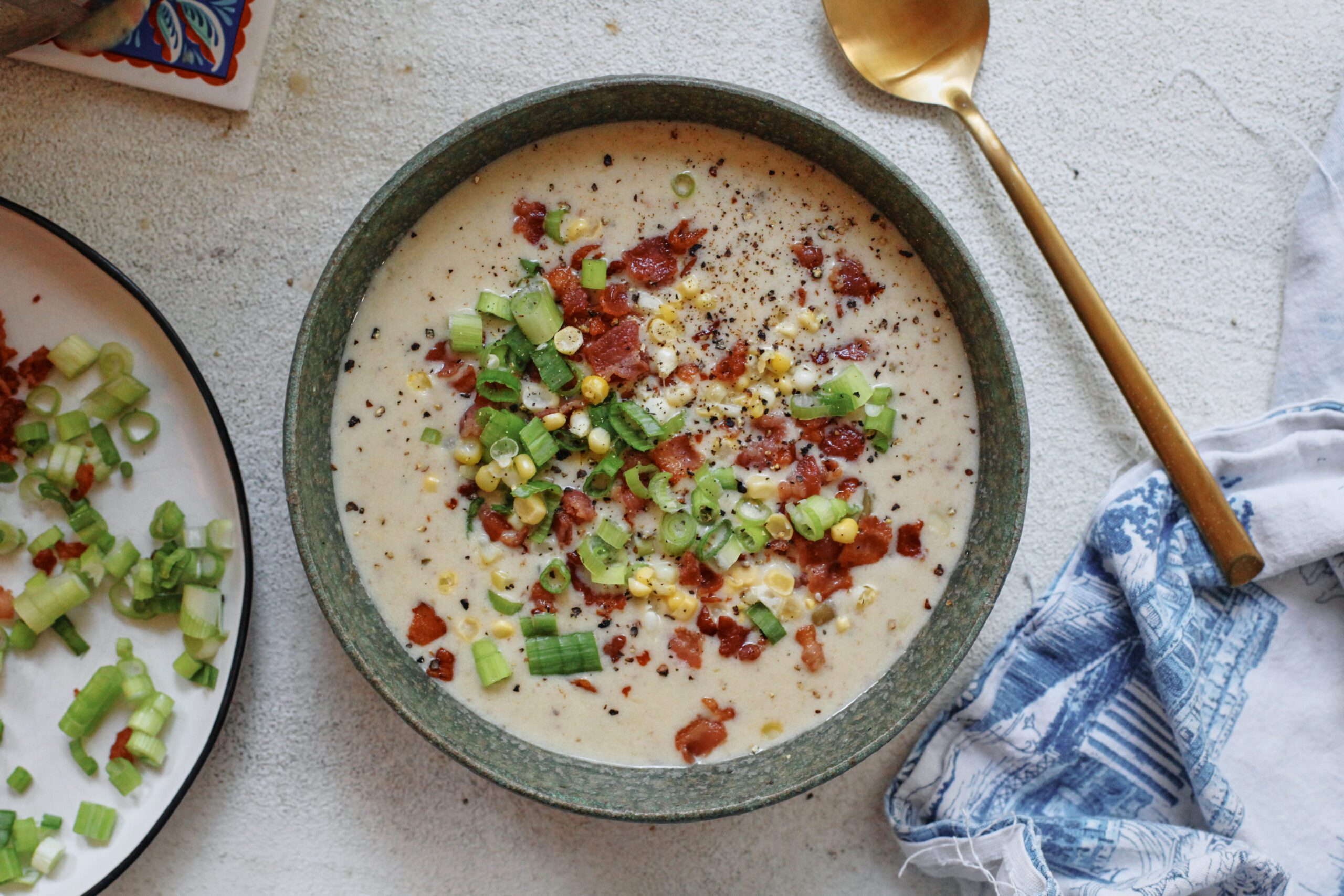 creamy corn chowder topped with green onions, bacon, and black pepper