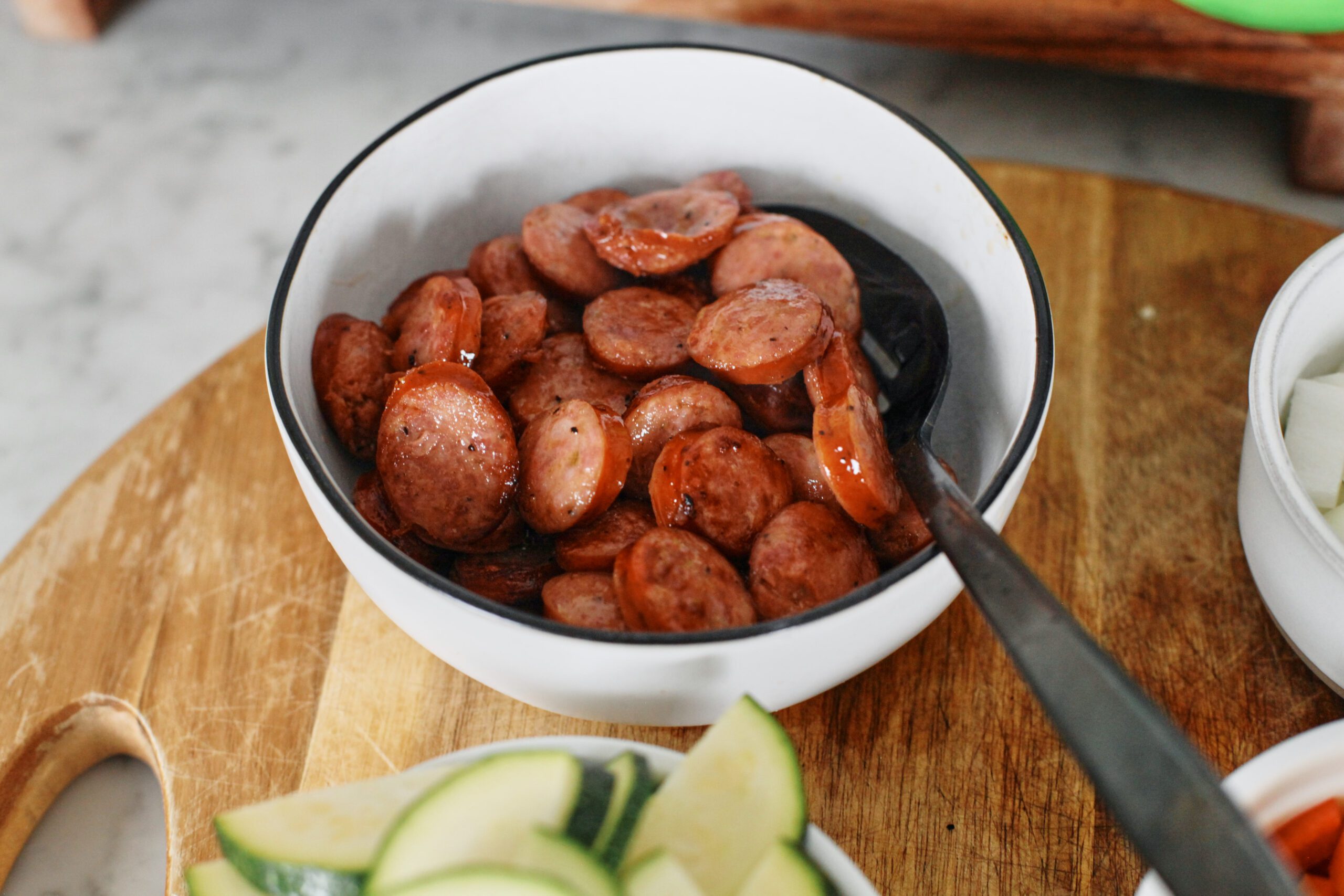 sautéed sliced sausages in a white bowl