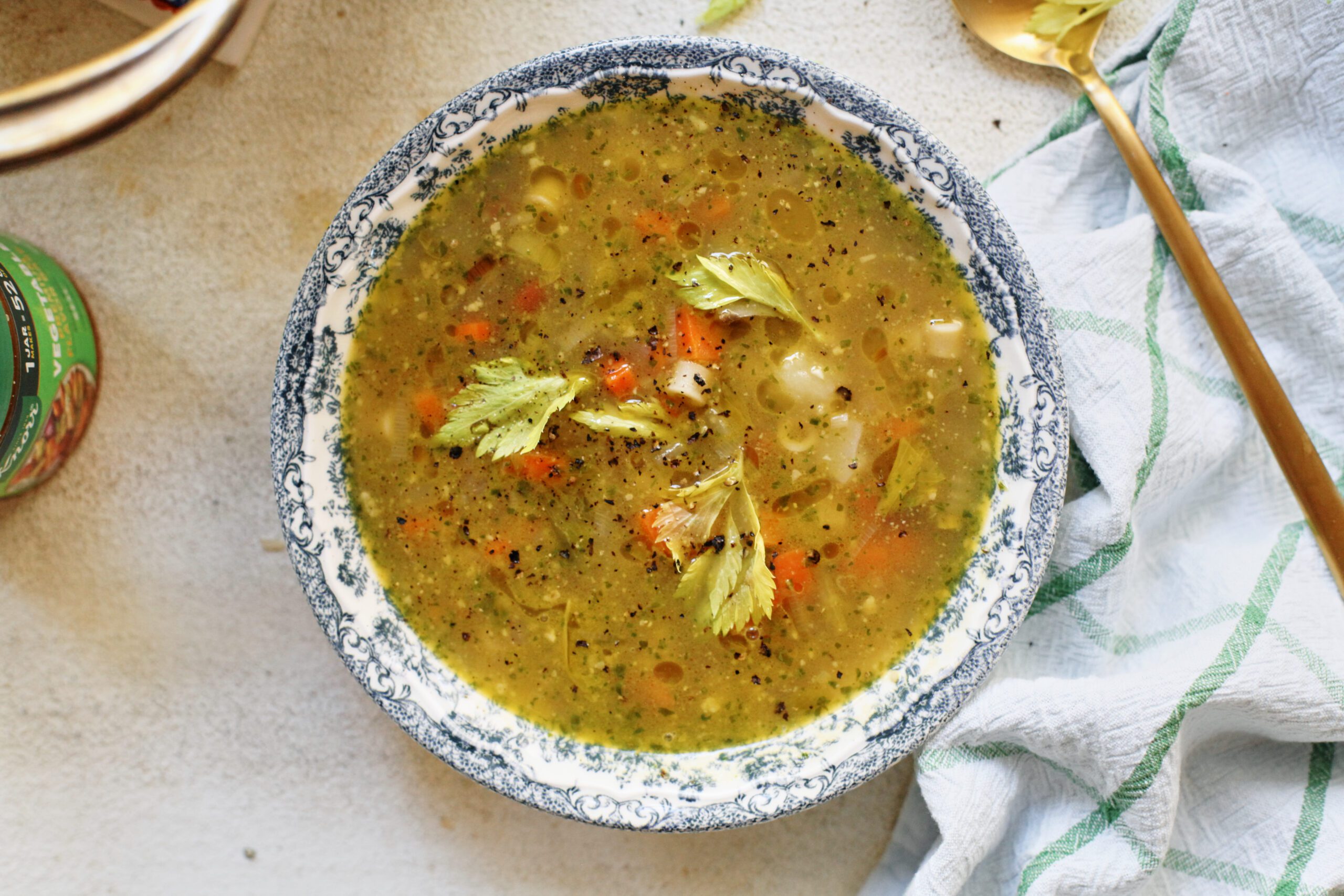 pesto minestrone soup in a white and blue floral-patterned bowl