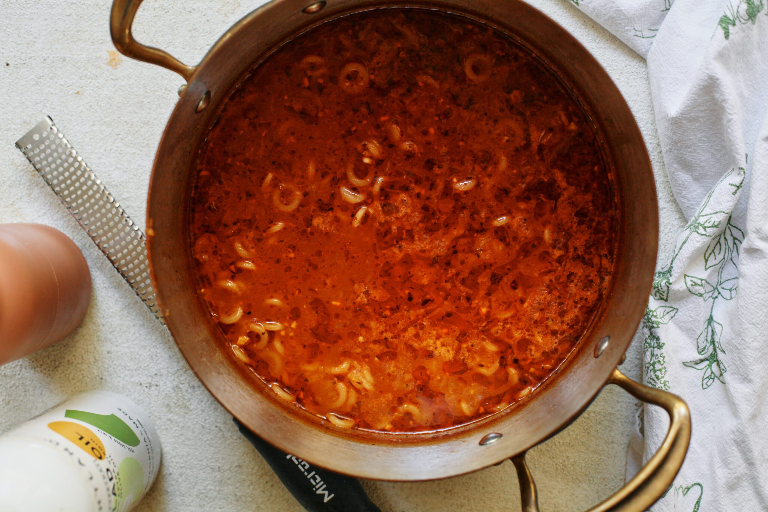 a large pot of brothy parmesan spaghetti soup