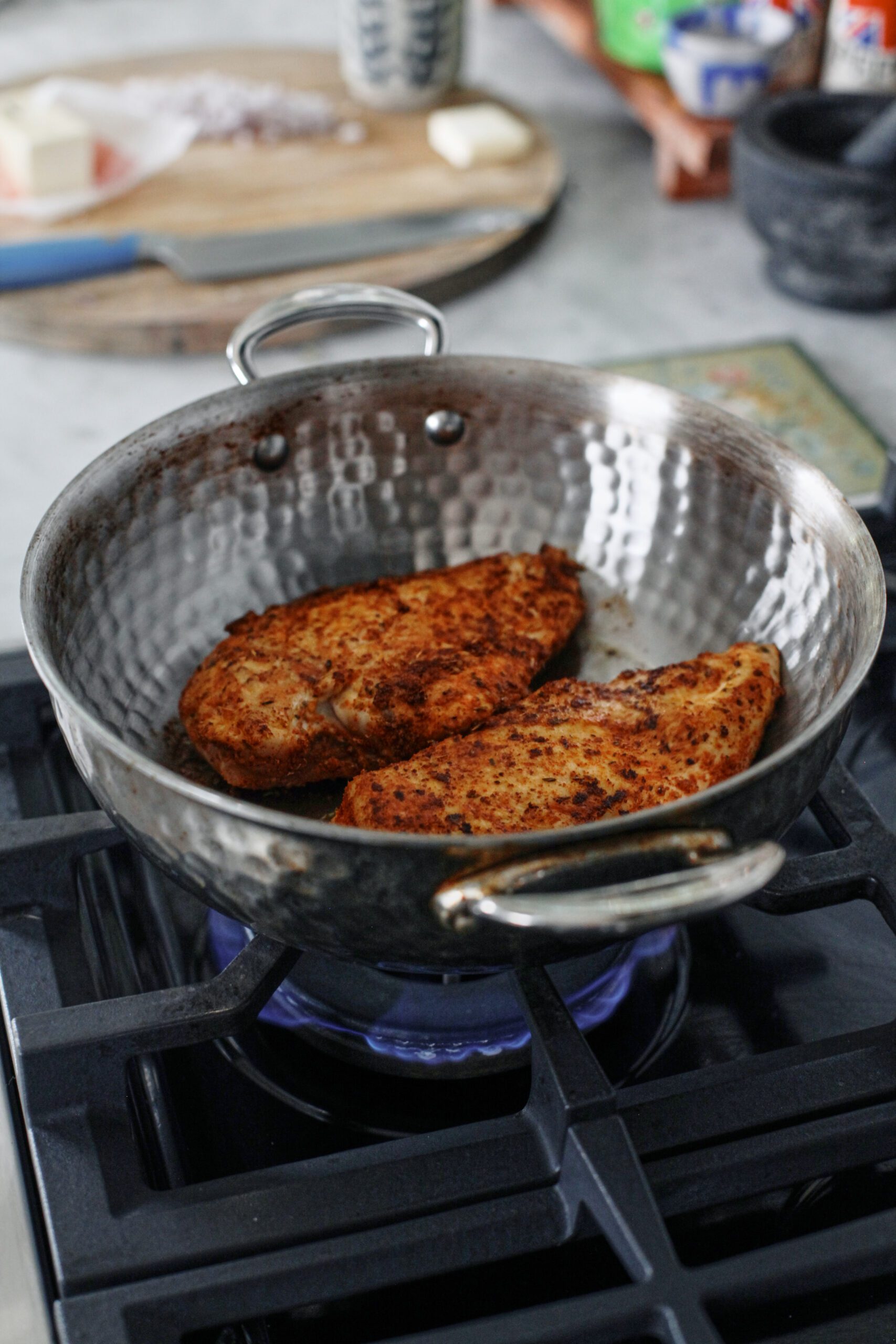 chicken breasts searing in a pan