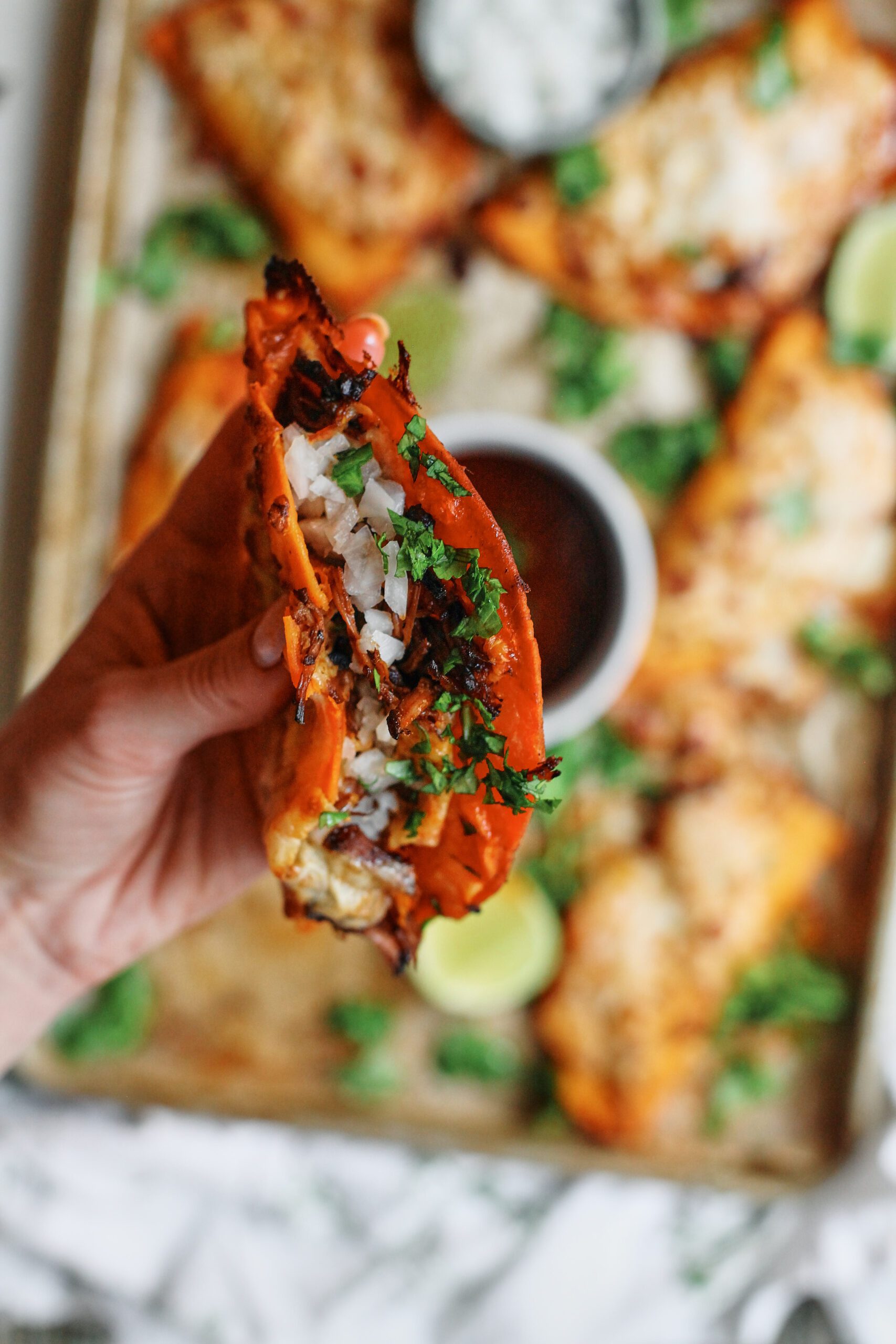 birria sheet pan tacos + a bowl of consomme dressed with cilantro, lime wedges, and a bowl of chopped white onions