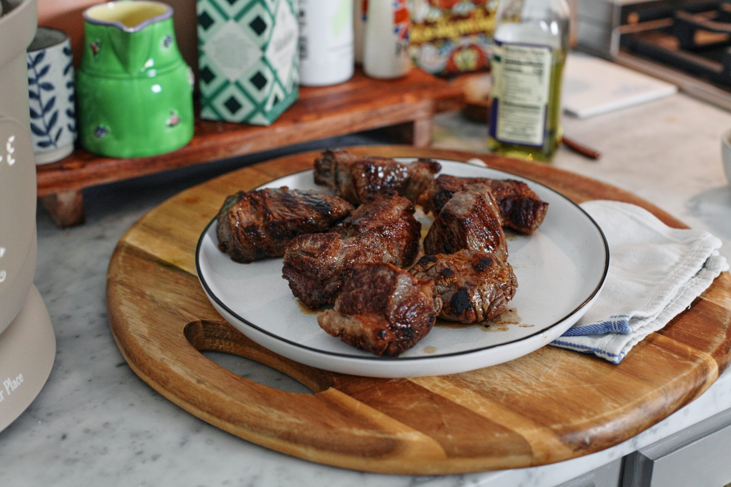 chuck roast pieces on a white plate after being seared in the pressure cooker