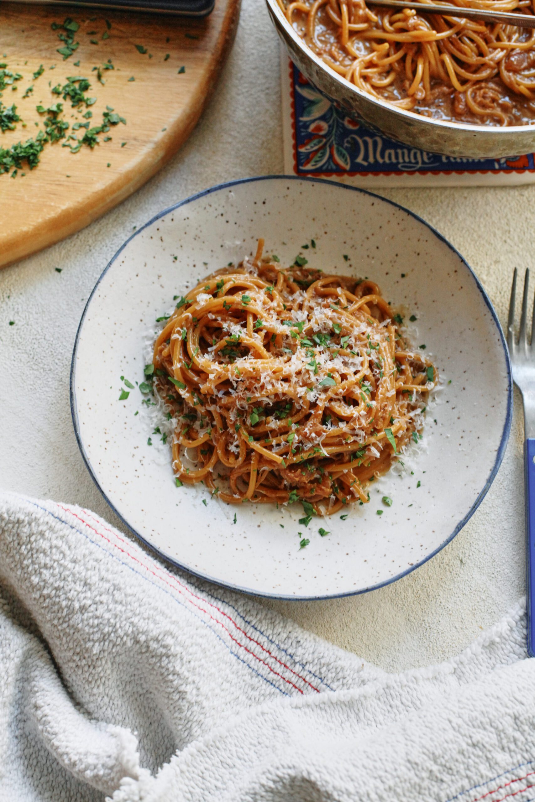 French onion spaghetti in a shallow white bowl with a black rim