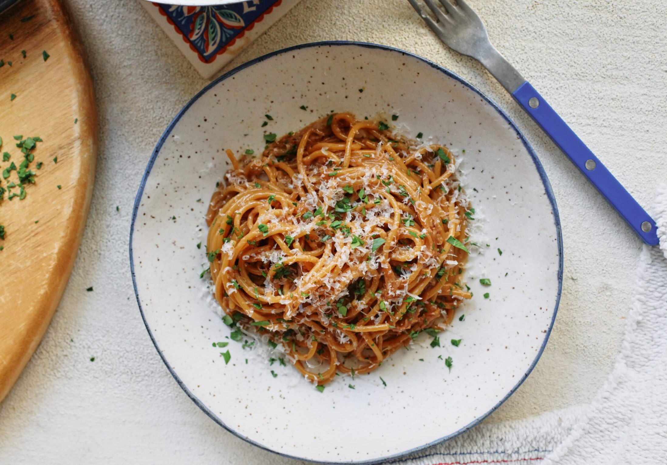 French onion spaghetti in a shallow white bowl with a black rim