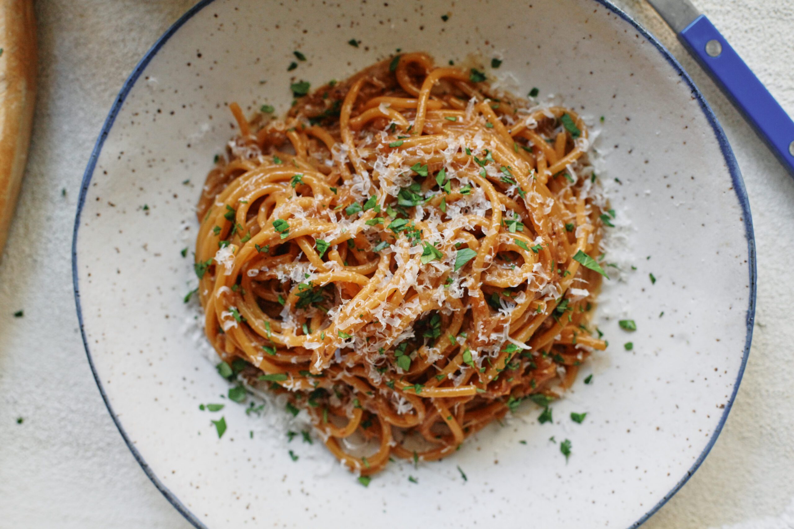 French onion spaghetti in a shallow white bowl with a black rim