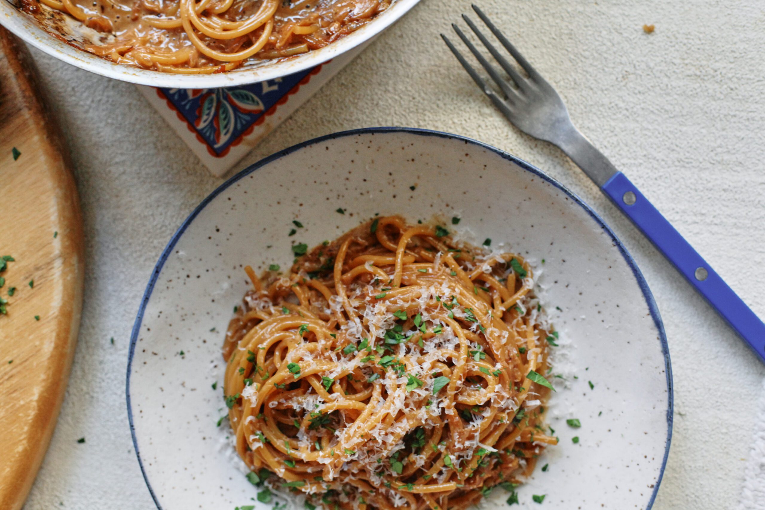 French onion spaghetti in a shallow white bowl with a black rim