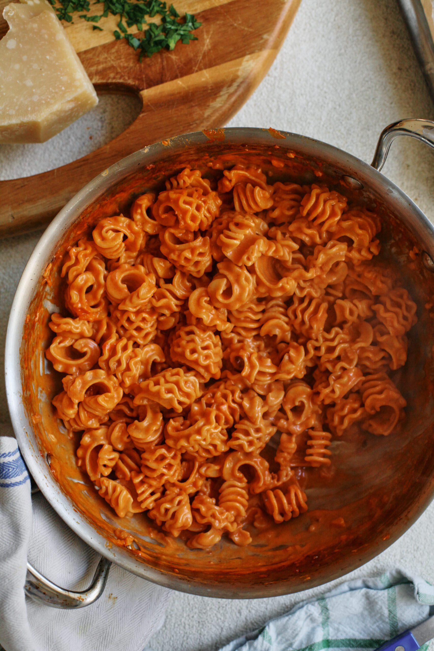a large hammered steel saute pan filled with vodka sauce covered radiatore